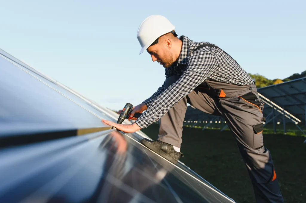 Techniker montiert Solarmodule auf einem Dach, Solarpflicht für Neubauten